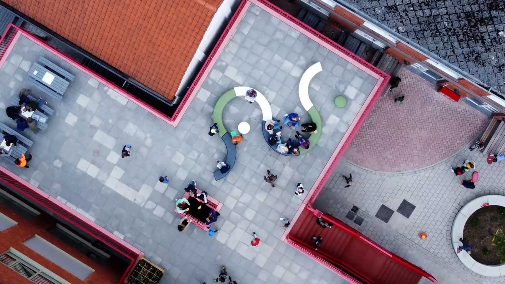 Plusieurs bancs LOOP disposés l'un après l'autre en extérieur et vue de haut.